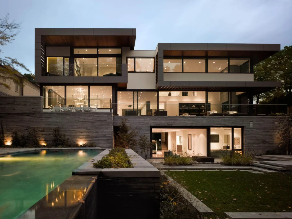 Contemporary luxury villa at twilight with glass and reflecting pool by Mehshan