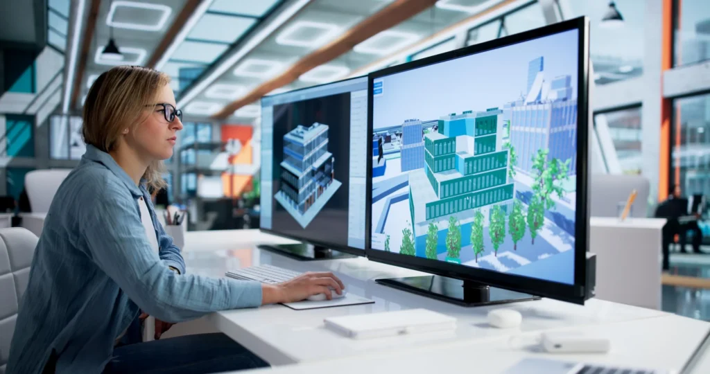 Female 3D designer creating commercial building visualisations on dual monitors