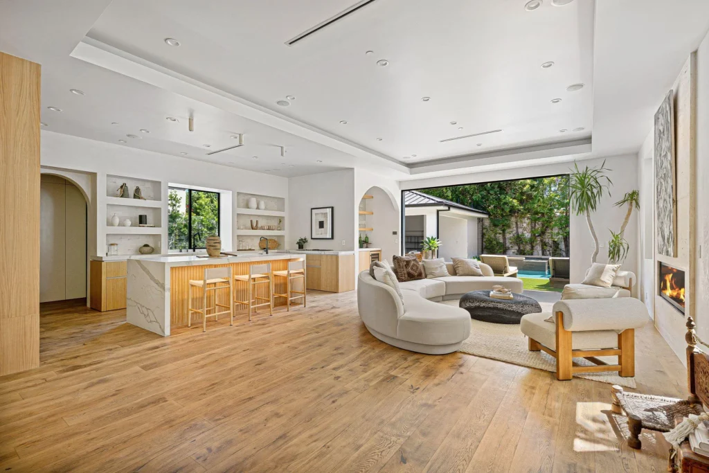 Modern open-plan kitchen and living area with marble island and white cabinetry