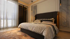 Cozy bedroom with dark leather headboard and patterned rug at Peace Apartments