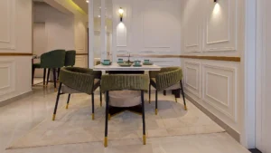 Elegant dining area with green chairs and marble table at Peace Apartments