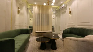 Elegant lounge with green sofas and wall panels at Peace Apartments Karachi