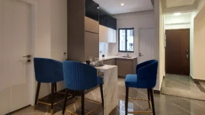 Modern kitchen with breakfast bar and blue chairs at Peace Apartments Karachi