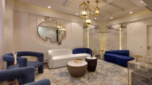 Luxury lounge with blue sofas and ornate chandelier at Peace Apartments Karachi